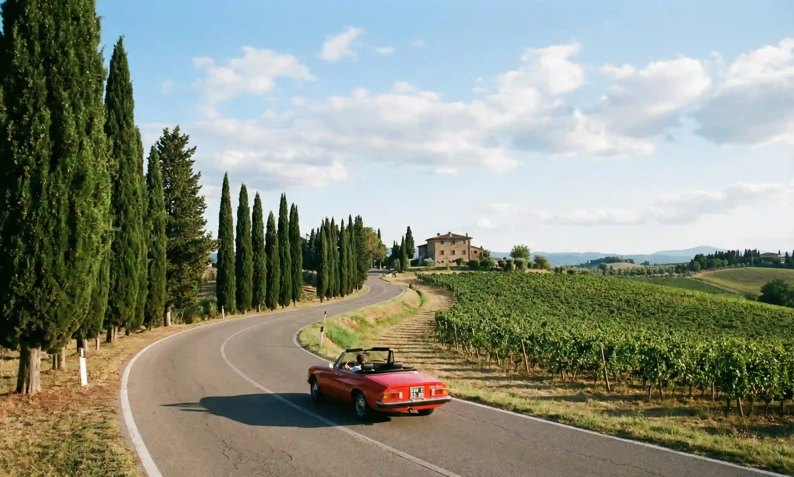 The winding Via Chiantigiana road through Chianti vineyards with cypress trees